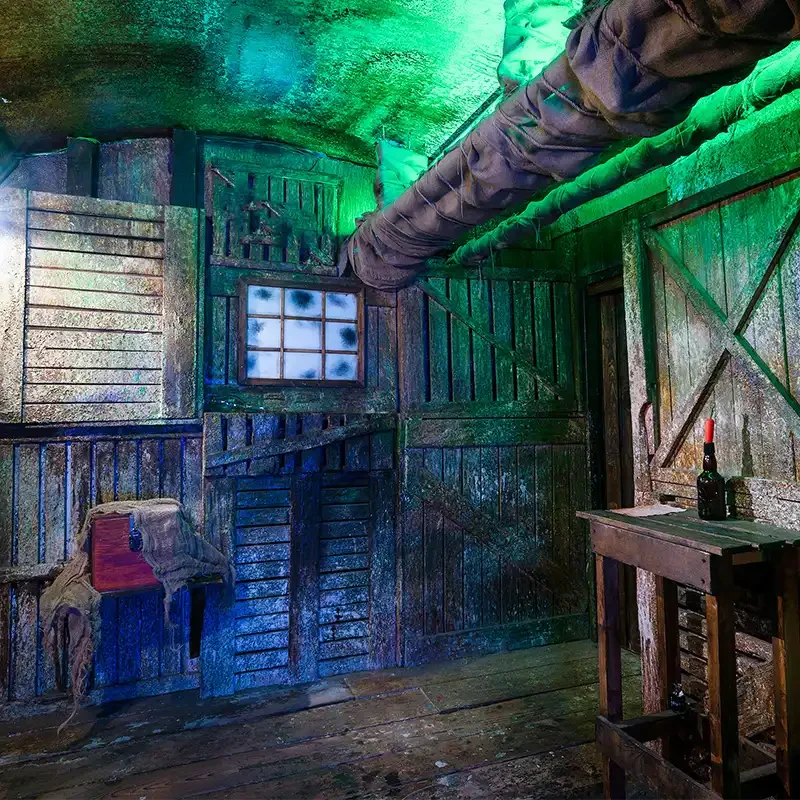 Verwitterte Schiffskulisse mit Holzwänden, Rohren, kleiner Luke und Tisch als Film- und Foto-Location bei Final Escape Basel.