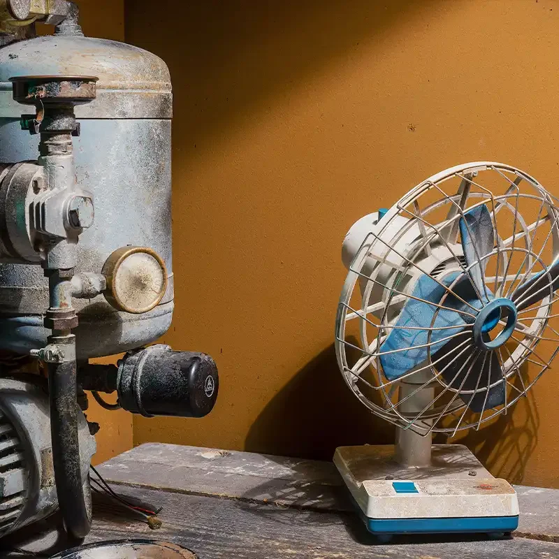 Detailaufnahme aus dem Escape Room Prison Break bei Final Escape Zürich mit alter Maschine, Ventilator und Werkbank in düsterer Gefängnisatmosphäre.