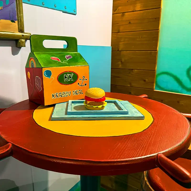 Detailreiche Küchenkulisse im Escape Room Krabbenburger in Zürich mit Pfannen, Bilderrahmen und verspielter Restaurant-Dekoration.