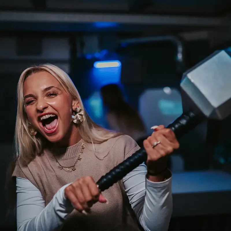Teilnehmerin hält einen Hammer als Requisite bei einem Junggesellenabschied im Escape Room Zürich