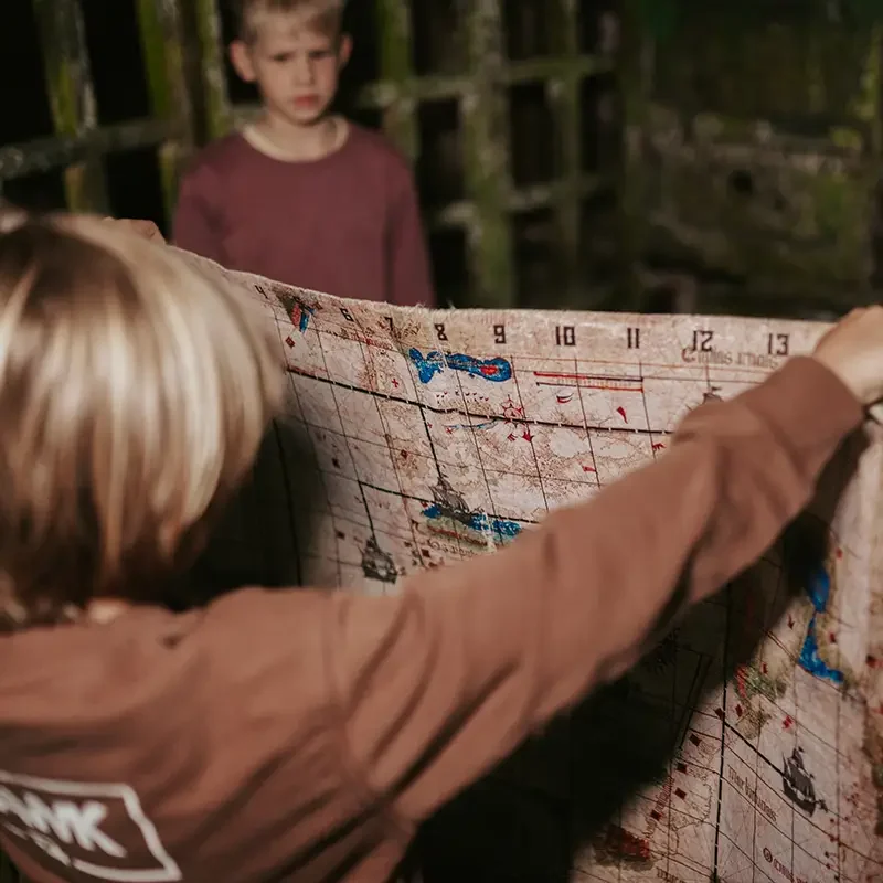 Kinder lösen bei einem Schulausflug in Zürich gemeinsam ein Kartenrätsel im Escape Room