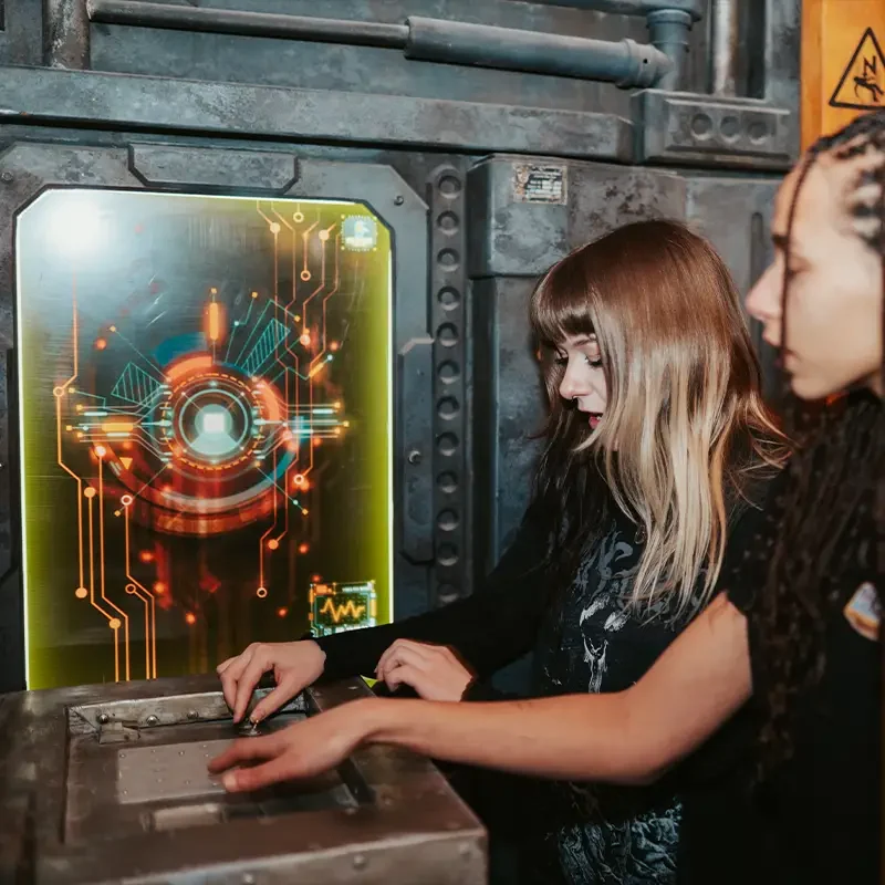 Teamevent im Escape Room Zürich mit zwei Spielerinnen beim Lösen eines technischen Rätsels